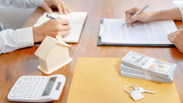 Property investment concept, image of small house model on the table. and home loan insurance. 