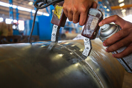 Male worker test steel pipeline butt weld carbon background white contrast