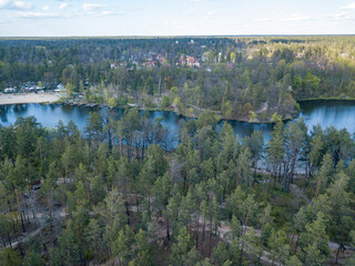 Lake in the coniferous forest in spring. Aerial drone view.