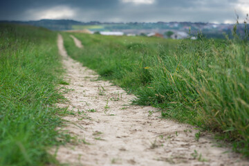 Rural road through field with sun beams. Soft focus