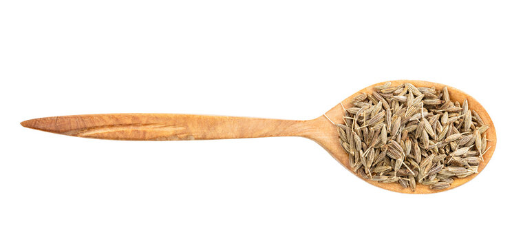 top view of wood spoon with cumin seeds isolated