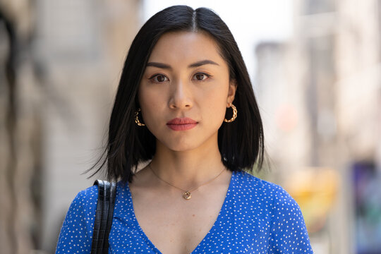 Young Asian woman in city serious face portrait