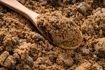 spoon with dark muscovado cane sugar on pile