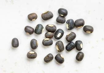 several whole black urad beans close up on gray