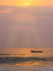 Boat fishing in the sea with sunrise light