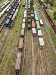 Freight trains on railway tracks. Aerial drone top view. Sunny spring day.