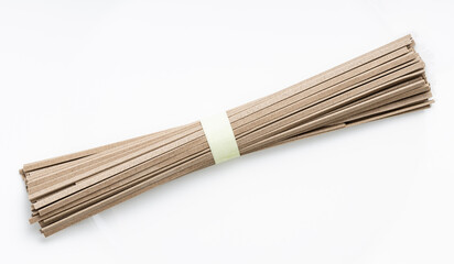 bunch of dried flat Soba noodles on white plate