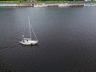 Fototapeta na wymiar The yacht is sailing along the river. Aerial drone view.