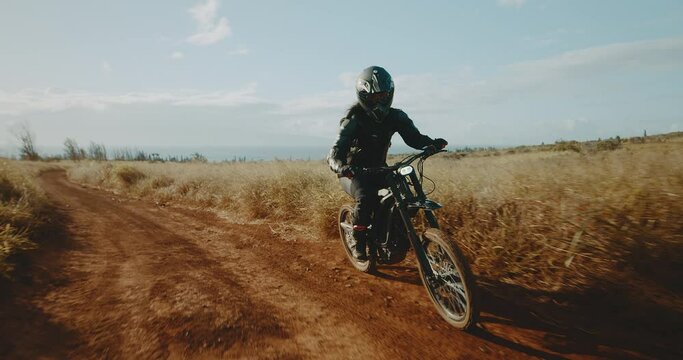 Woman riding electric dirt bike, adventure active outdoor lifestyle, cinematic slow motion