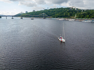 The yacht is sailing along the river. Aerial drone view.
