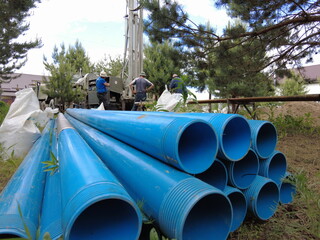 Europe, Kiev region, Ukraine - June 2021: Food pipes close-up. An engineer drills a well for water. Drilling rig worker during work. Drilling water wells.