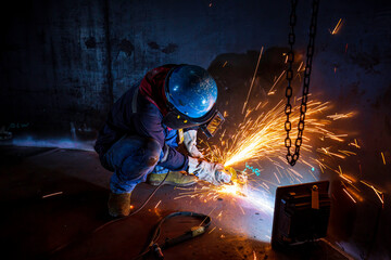 Male worker  grinding on steel plate with flash of sparks close up wear protective gloves