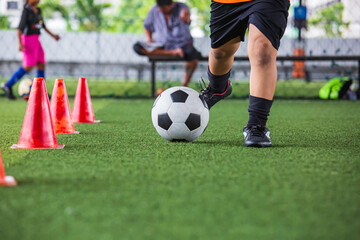 Children playing control soccer ball tactics on grass field with for training