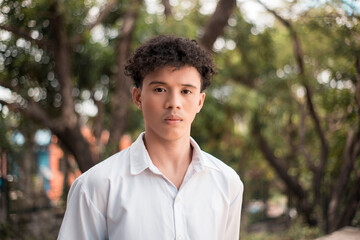 A serious and unimpressed Asian African college student showing contempt and dislike in his eyes....
