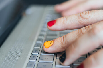 A young hipster freelancer is typing on a keyboard. Selective focus on the middle fingers on left...