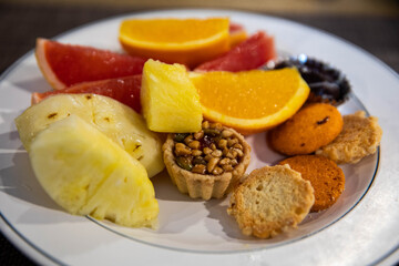 Sweet dessert with grapefruit, orange, pineapple and sweets on plate