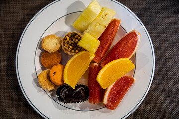 Sweet dessert with grapefruit, orange, pineapple and sweets on plate