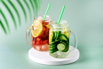Fototapeta na wymiar Variety of Cold Summer Drinks in Glass Jars Infused Detox Water with Cucumber Lemon and Strawberry Healthy Drink Green Background Horizontal