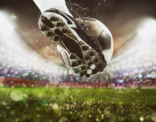 Football scene at night match with close up of a soccer shoe hitting the ball with power © alphaspirit