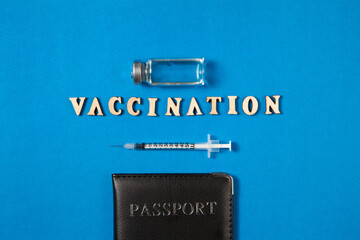 Vaccine bottles, syringe injection medicine and passport on blue background with empty blank space.
