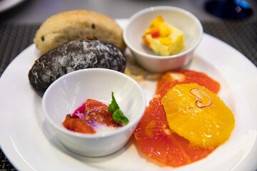 Sweet dessert with grapefruit, orange, bread and snacks on a plate