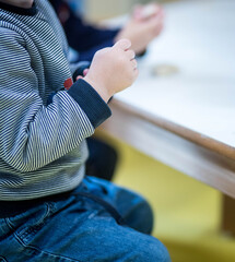 enfant qui joue à la pate à sel devant une table, zoom sur les mains