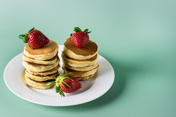 Freshly Baked Homemade Mini Pancakes on a Plate Fresh Berry Tasty Breakfast Green Background Horizontal
