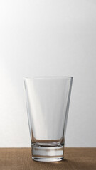 Empty glass vase on a wooden base. Vertical.