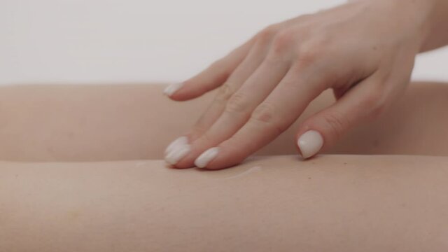 Anti cellulite care. Caucasian lady applying fat burning cream on her hips skin, enjoying spa procedures herself
