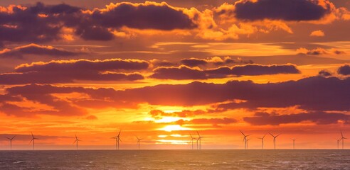Renewable green electricity wind power generation offshore. Sunrise at decarbonization industry windmills business for regenerative energies. Clean energy renewables preventing climate change - 438461463