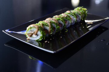 Sushi rolls on black dish. Japanese food.