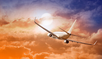 airplane flying above clouds in sunset light.