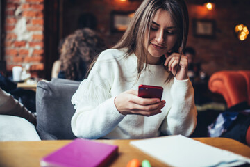 Smiling woman text messaging on smartphone