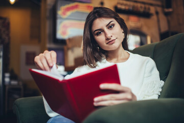 Thoughtful female student with notebook in cafeteria