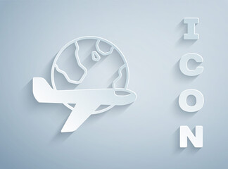 Paper cut Globe with flying plane icon isolated on grey background. Airplane fly around the planet earth. Aircraft world icon. Paper art style. Vector