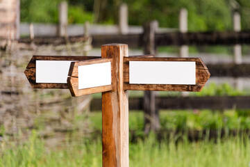 Empty wooden sign with arrows on the ranch. Simple wooden triple direction arrow roadsign.