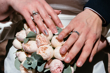 hands of young people with wedding wedding rings. wedding day details. calla flowers. spouses newlyweds groom and bride
