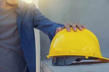 Worker architect holding yellow helmet in building construction