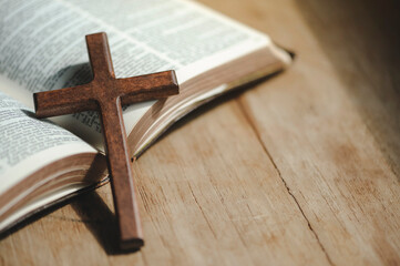 A cross with the holy bible is placed on a wooden table on Sunday. worship prayer and bible study...
