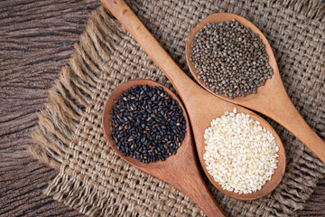 mix sesame seeds with spoon on wood table.
