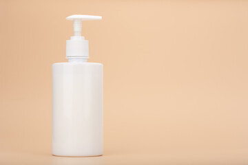 Shower gel, liquid soap or intimate gel in white unbranded tube against light beige background with copy space. Concept of intimate hygiene or gel for sensitive skin