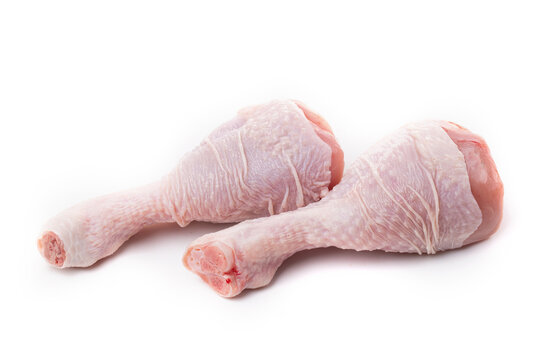Raw chicken legs with skin on a white background.