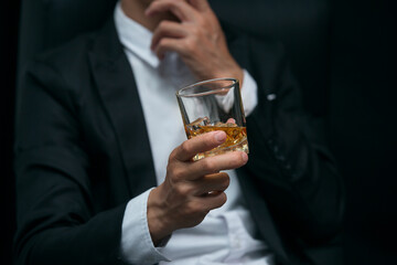 Man wearing a suit whiskey glass of liquor 