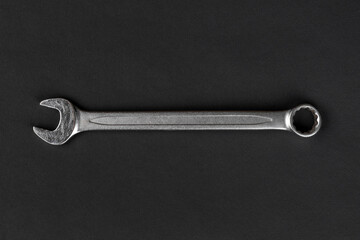 Wrench on black paper background, steel hand work tool