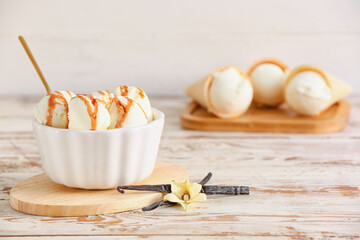Ramekin with tasty vanilla ice cream on light wooden background, closeup