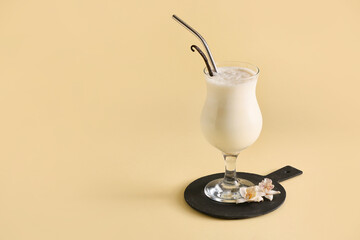 Glass with tasty vanilla milkshake on color background