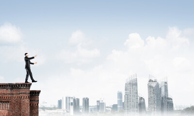 Danger and risk concept with businessman making step from edge