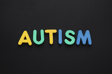 Word AUTISM on dark background