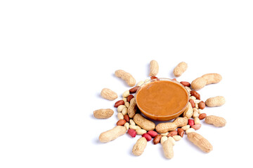 Peanut butter isolated and peanuts in the peel scattered on the white background. Copy space.