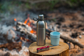 Thermos and a mug in nature.